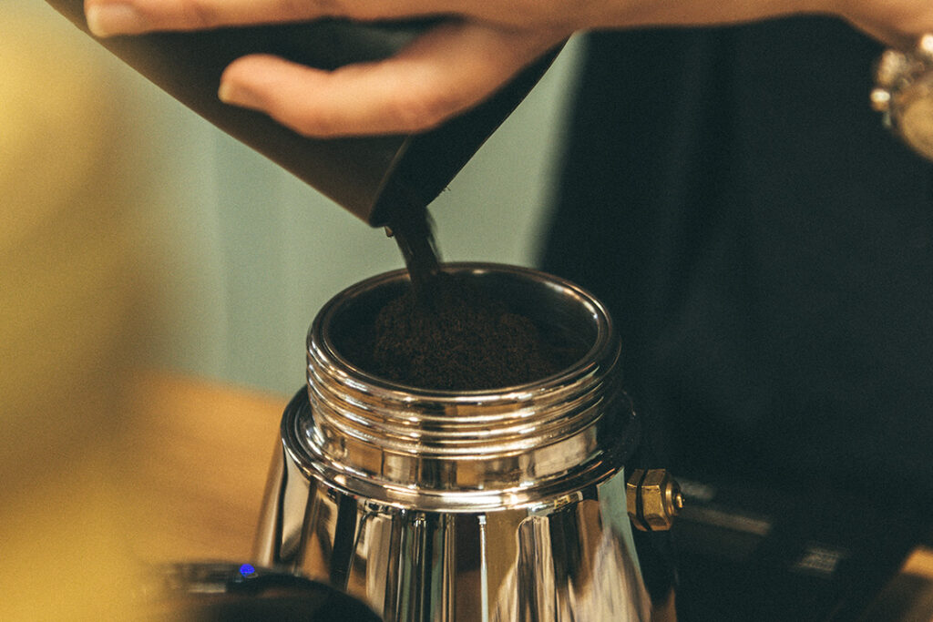 Gemahlener Kaffee wird in den Siebtrichter einer Bialetti gefüllt
