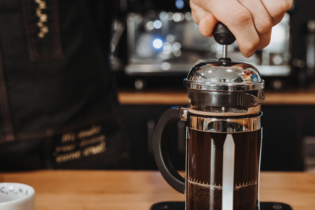 French Press Stempel wird langsam nach unten gedrückt
