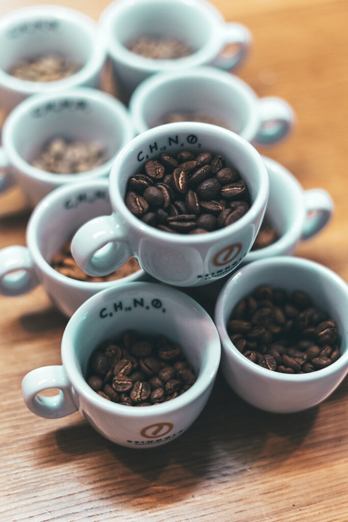 Kaffee Röstgrade im Vergleich mit unterschiedlich gerösteten Kaffeebohnen in Tassen
