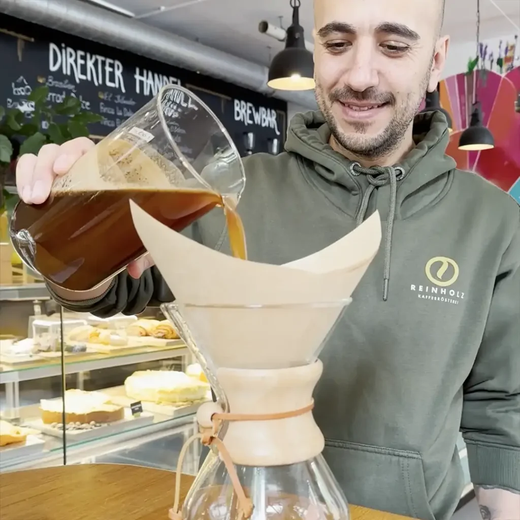 Barista Anton filtert frisch zubereiteten Cold Brew Kaffee durch einen Papierfilter in der Reinholz Kaffeerösterei.