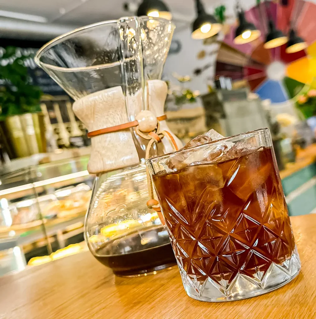 Frisch zubereiteter Cold Brew Kaffee mit Eiswürfeln im Glas. Die helle orange-braune Farbe zeigt die sanfte Extraktion des Kaffees.
