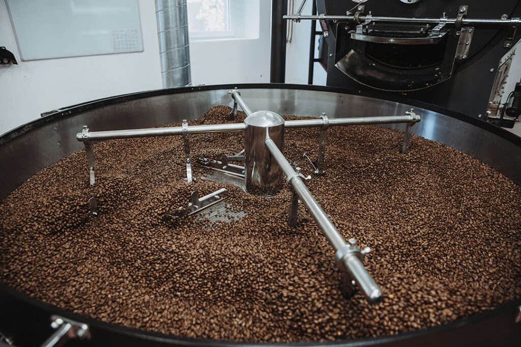 Frisch gerösteter Kaffee kühlt im Kühlsieb nach der Trommelröstung ab