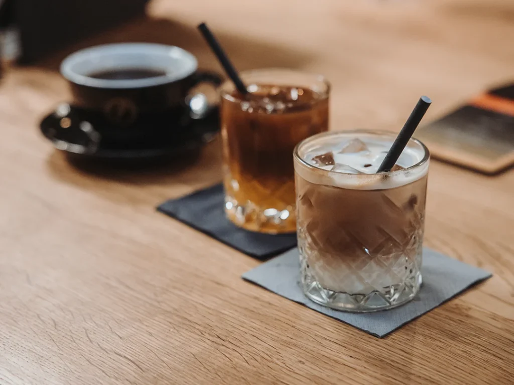 Verschiedene kalte Kaffeegetränke mit Eiswürfeln und Milch im Glas bei Reinholz.